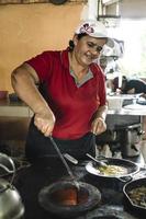 mulher cozinha em um fogão a lenha foto