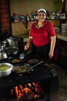 mulher cozinhando em um fogão a lenha. foto