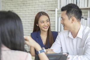 feliz casal apaixonado conversando com seu agente imobiliário com sorriso olhando para casa, planejando o futuro do conceito de família foto