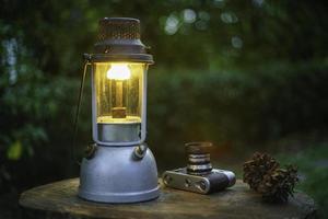 lâmpada de óleo antiga em um piso de madeira no fundo preto à noite.