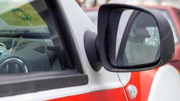 espelho retrovisor de plástico preto do lado direito em um carro branco. espelho retrovisor externo do lado do passageiro, ajustável eletricamente e aquecido. foto