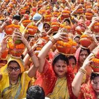 nova delhi, índia 03 de abril de 2022 - mulheres com kalash na cabeça durante o templo jagannath mangal kalash yatra, devotos hindus indianos carregam potes de barro contendo água sagrada com um coco no topo foto