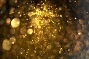 textura de iluminação de bokeh de brilho dourado turva fundo abstrato para aniversário, aniversário, casamento, véspera de ano novo ou natal foto