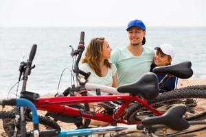 família com bicicletas na praia foto