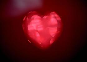 forma de coração de borrão vermelho de ligth bokeh em um fundo preto foto