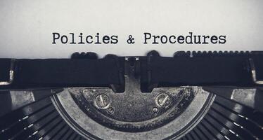 texto de políticas e procedimentos digitado em uma velha máquina de escrever vintage. conceito de regras