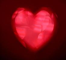 forma de coração de borrão vermelho de ligth bokeh em um fundo preto foto