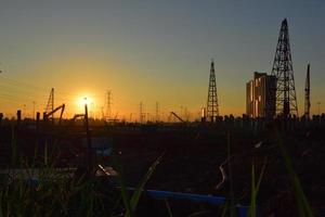 canteiro de obras e poste elétrico com céu do nascer do sol foto