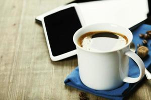 xícara de café com computador tablet digital e telefone inteligente
