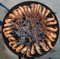 camarão grelhado em uma armação de aço com fogo quente foto