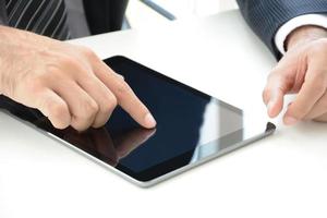 mão de empresário tocando a tela do tablet pc em cima da mesa