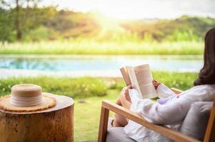 mulher relaxante lendo livro no parque no outono foto