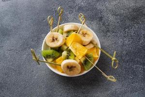 frutas frescas em espetos para fondue. mesa para espaço de cópia de festa de verão foto