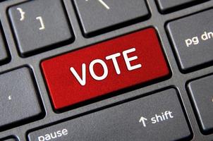 conceito de votação - teclado de laptop com botão de voto vermelho. foto