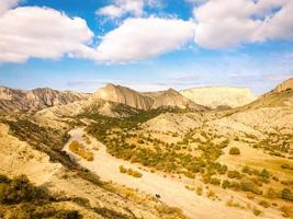 vista panorâmica aérea da paisagem da área protegida do parque nacional de vashlovani com jipe na estrada passando em primeiro plano foto