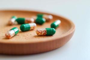 cápsulas solúveis intestinais com vitaminas em uma placa de madeira. close-up, foto macro