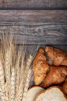 croissants e pães na velha mesa de madeira foto