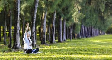 mulher praticando relaxantemente ioga meditação na floresta de pinheiros para alcançar a felicidade da sabedoria da paz interior para o conceito de mente e alma saudável foto