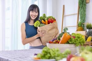 mulher japonesa asiática segurando a sacola de compras do supermercado cheio de vegetais orgânicos e frutas para alimentação saudável e salada vegetariana com espaço de cópia foto