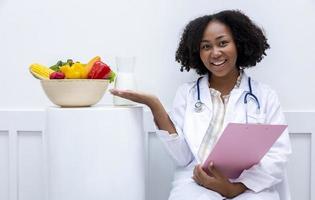 retrato de nutricionista americano africano com tigela de variedade de frutas e vegetais para dieta saudável e conceito de reforço de vitamina foto