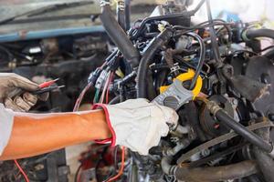 mecânico de automóveis trabalhando no motor do carro na garagem da mecânica, serviço de reparação e manutenção, conceitos de manutenção e reparação foto