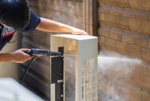 reparador lavando compartimentos sujos condicionador de ar, técnico masculino limpando condicionador de ar dentro de casa, conceitos de manutenção e reparação foto