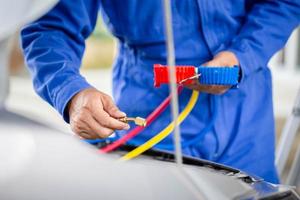 técnico verifica a recarga de refrigerante do sistema de ar condicionado do carro, reparador segurando a ferramenta de monitor para verificar e fixa o sistema de ar condicionado do carro, reparo de ar condicionado foto