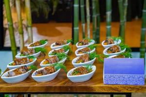 rolinhos de carne e vegetais grelhados com molho picante. comida de coquetel aplicada entre estilo moderno e comida tailandesa local pronta para servir em evento de jardim ao ar livre. foto