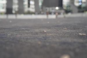 feche o chão de asfalto na área de estacionamento com bokeh atrás. foto