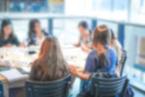 Garota de adolescentes embaçadas apenas se senta ao redor da mesa na loja de departamentos, cantina com muito livro e suporte de tecnologia. foto