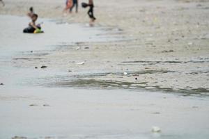 lixo na praia de bangsaen, chonburi, tailândia em pessoas e dia de férias do turista. foto