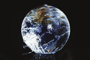 uma bola de vidro sobre a qual a água flui foto