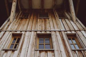 uma velha casa de madeira com janelas de madeira rústicas foto