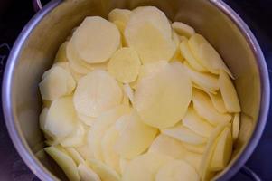 batatas descascadas em fatias finas em uma tigela foto