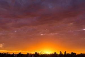 espetacular pôr do sol laranja e roxo vívido foto