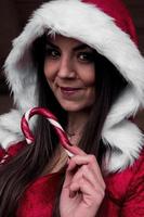 menina fantasiada de papai noel com capa de doces foto