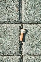 bituca de cigarro na calçada foto