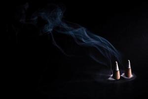 incenso com fumaça branca em fundo preto foto