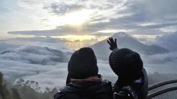 wonosobo, Indonésia, 23 de dezembro de 2019 . dieng, duas garotas estão curtindo férias, elas estão em uma colina sikunir apreciando o nascer do sol e as vistas da montanha foto