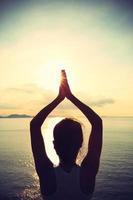 meditação de mulher ioga saudável à beira-mar do nascer do sol