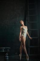 a linda bailarina posando contra o fundo escuro foto