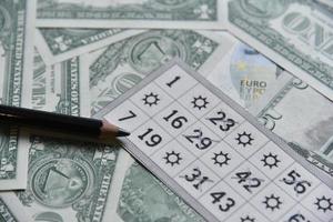 notas de dólar e bilhetes de loteria com um lápis foto