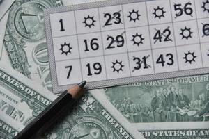notas de dólar e bilhetes de loteria com um lápis foto