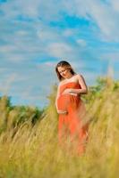 jovem mulher grávida ao ar livre foto