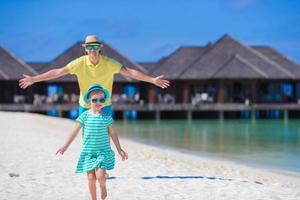 jovem pai e filha na praia tropical foto