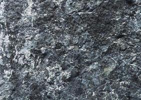 superfície de parede de rocha de granito escuro, textura de fundo abstrato. foto