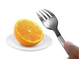 fruta laranja no prato e garfo isolado no fundo branco foto