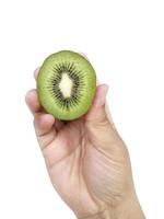 mão segura metade fatiada de kiwi isolado no fundo branco foto