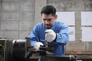 um trabalhador de engenheiro industrial masculino asiático profissional trabalha em um uniforme de segurança com ferramentas de precisão de metalurgia, tornos mecânicos e oficina de peças de reposição na fábrica de fabricação de aço. foto