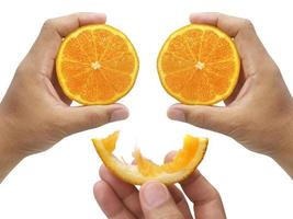mão segurando a fatia de laranja isolada no fundo branco foto